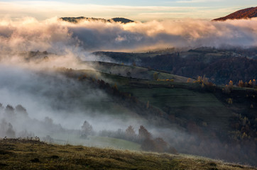 thick fog on hills in countryside at sunrise