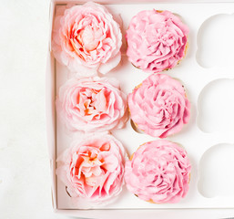 Pink cupcakes with roses in box. Festive and bright. Wedding Celebration concept. top view, flat lat