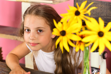 Kid and school supplies on pink wall background