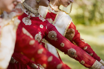 Arms of a dancing Indian women dressed in traditional sari at a park