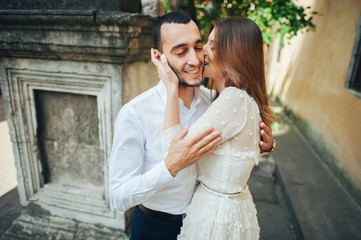 Naklejka premium Stylish lovely couple in warm hugs under the tree in the park at sunset