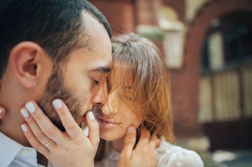 beautiful wedding couple hugging standing near old building