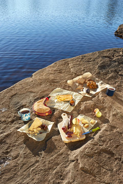Selection of cheeses, arranged on rock, beside lake, Colgate Lake Wild Forest, Catskill Park, New York State, USA
