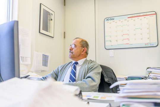 Male office worker using desktop computer at office desk