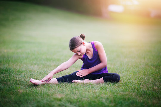 Girl stretching on grass