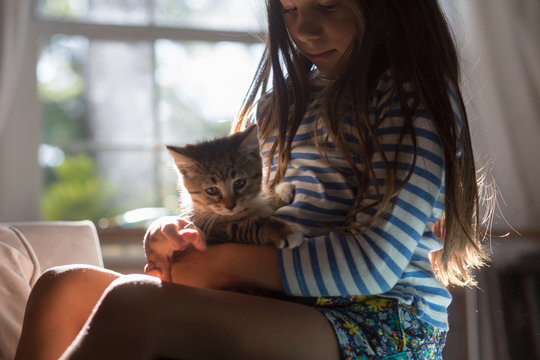 Girl with kitten sitting on lap