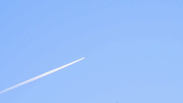 A reactor jet crosses the sky leaving a wake