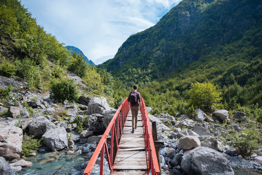 Rear view of man crossing bridge, Accursed mountains, Theth, Shkoder, Albania, Europe