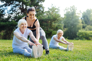 Fototapeta premium Happy pensioner woman doing task with trainer