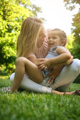 Mother and daughter outdoors in a meadow. Mother and daughter having funny conversation.