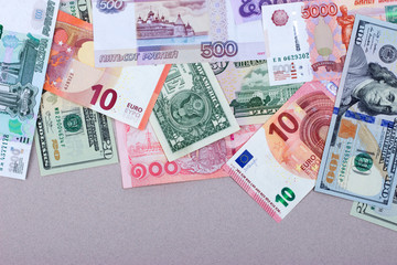 Бумажные деньги различных стран на пастельном фоне