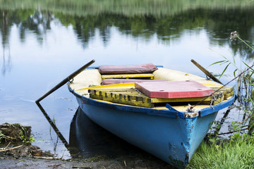 Obraz premium An old boat on the river bank. Summer sunny day.