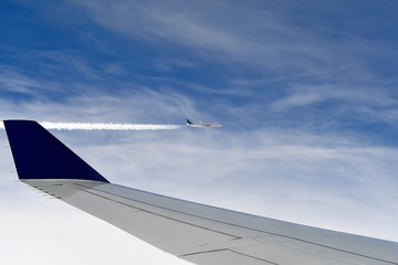 pair of jets in sky with vapor contrail