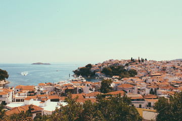Fototapeta na wymiar Skyathos panorama with white houses, ships on the sea and small pedestrian streets