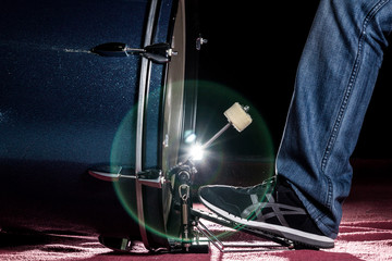 The drummer's foot wears sneaker is playing bass drum pedal