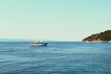 Small cruise ships at the sea near the Greek Islands. Calm sea and blue sky background.