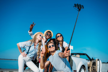 Fototapeta na wymiar multiethnic happy friends taking selfie together on smartphone