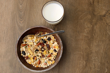 Muesli with nuts and tropical dried fruits. Healthy breakfast: flakes cereal in wooden plate.