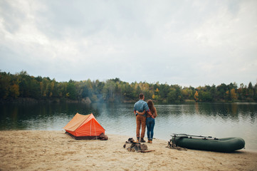 Young couple in love, boat ride on the river, next to the forest.
