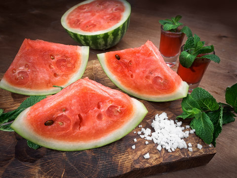 watermelon drink watermelon pieces in a rustic wooden background.