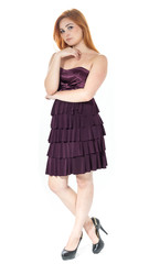 Full body portrait of young girl. Redheaded girl wearing dark purple strapless dress.