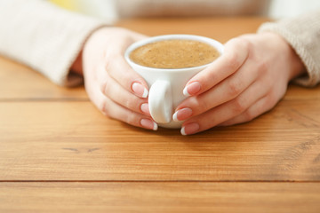 Female holding a cup of coffee, close up