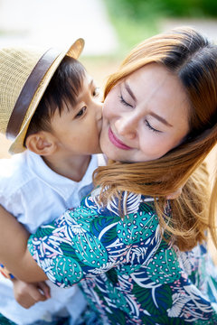 Asian boy kiss mother in the park.