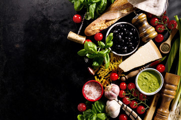 Tasty fresh appetizing italian food ingredients on dark background.