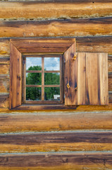 Obraz na płótnie Canvas The window with the wooden carved architrave in the old wooden house in the old Russian town.