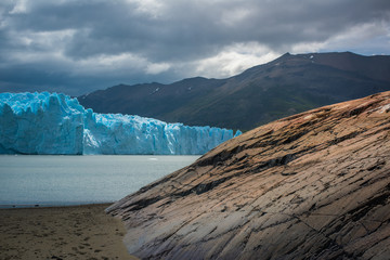 Blue glacier in the background of the mountains near the bay. Shevelev.
