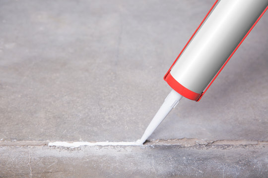 A person will seize a crack with silicone and sealant 