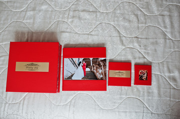Obraz premium Elegant red wedding photobooks or photo albums with golden inscription on the soft pastel background.