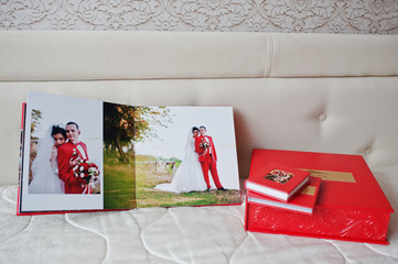Pages of elegant red wedding photobook or photoalbum on the soft beige background.