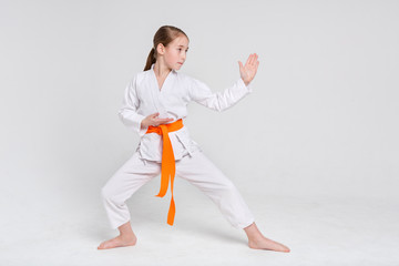 Karate girl in kimono in stand at studio background