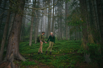 Fototapeta premium incredibly beautiful and young couple walking in the forest
