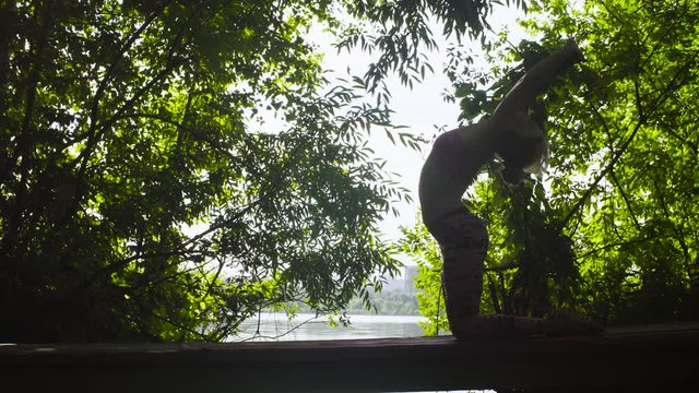 Woman doing yoga exercises against the trees