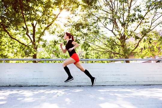 Beautiful Young Athlete Running On A Path In The City.