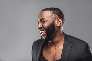 Cheerful successful young  African American man studio portrait in full suit 