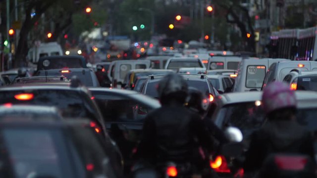 Traffic Jam in the city, big avenue / residential / business area. Cars, vehicles, motorcycles & pedestrians. Dusk. / blurred. 4k.
