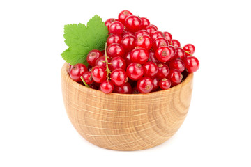 Red currant berries in a wooden bowl with leaf isolated on white background
