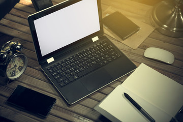 Laptop computer with desk lamp and office equipment.