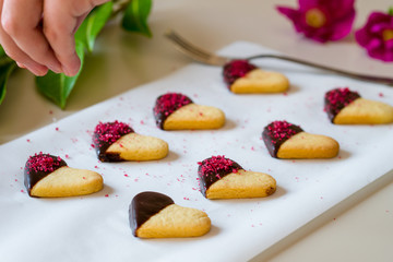 Making heart shaped cookies with red sweet crumbs and chocolate. valentine's day gift