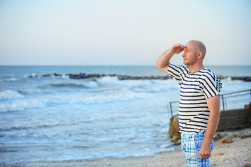 man is standing by the sea and looking into the distance