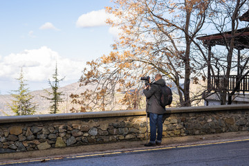 Travel, vacation, photographer and hitchhiker concept - traveler man photographed town
