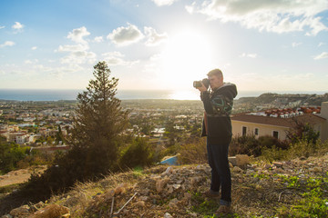 Traveler photographer with digital camera on top of the mountain.