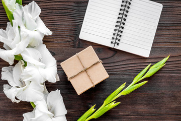 Celebration accessories. Box in kraft paper and notebook on wooden table top view