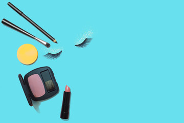 Makeup products on blue background, flat lay