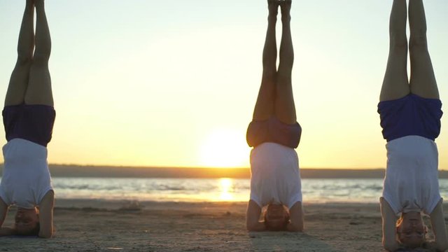 People support headstand yoga pose salamba sirshasanasunrise rapid slow motion 
