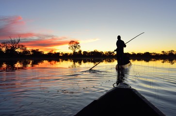 Saling in the Okavango delta at sunset, Botswana