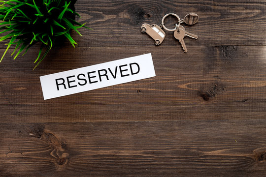 Book hotel. Word reserved near room keys on dark wooden table background  top view copyspace Stock Photo | Adobe Stock